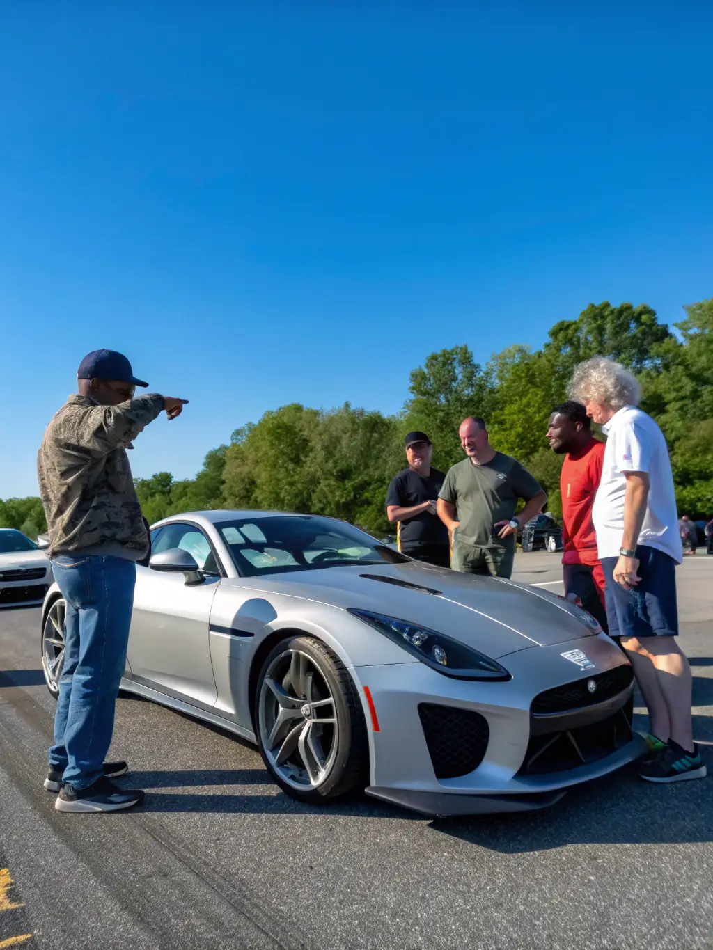 A diverse group of people participating in an automobile-related activity, highlighting the inclusive and community-focused nature of ECURIE AUTOMOBILE PAYS D'AUGE.